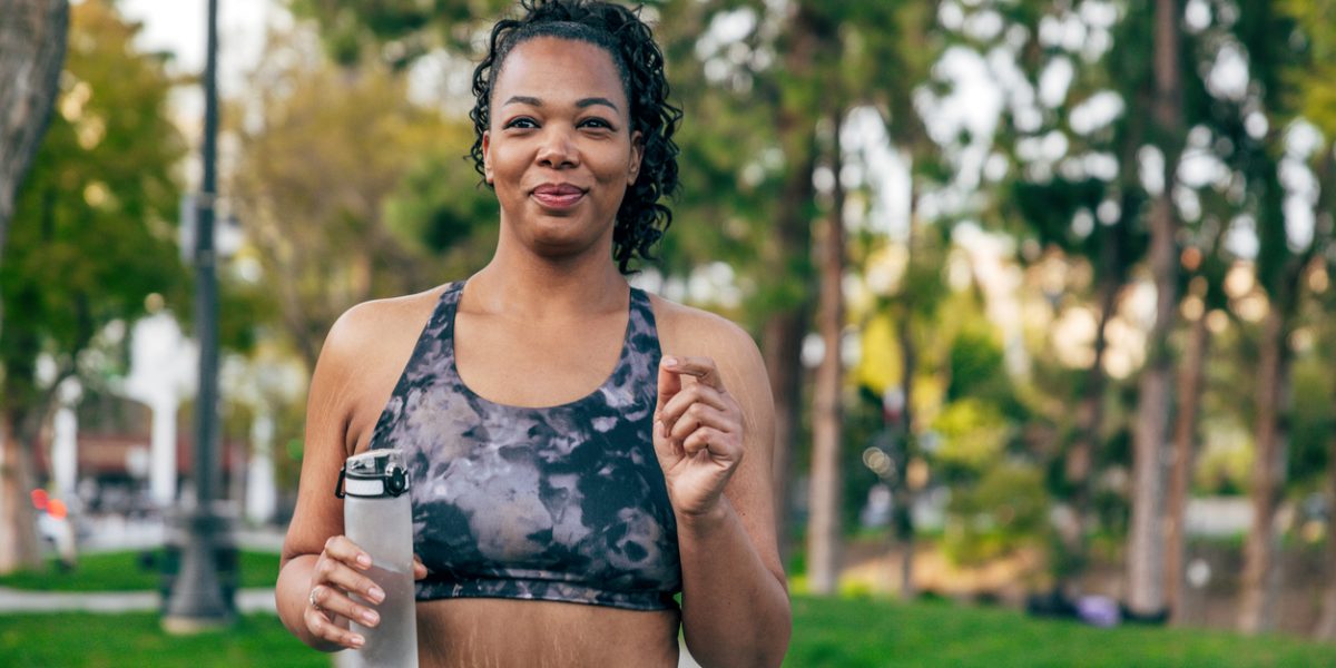 In a sunny day a black woman jogging and enjoying the morning in a park near to Downtown Los Angeles, California.