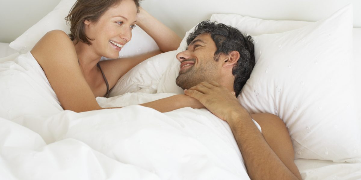 Woman and man lying down in bed